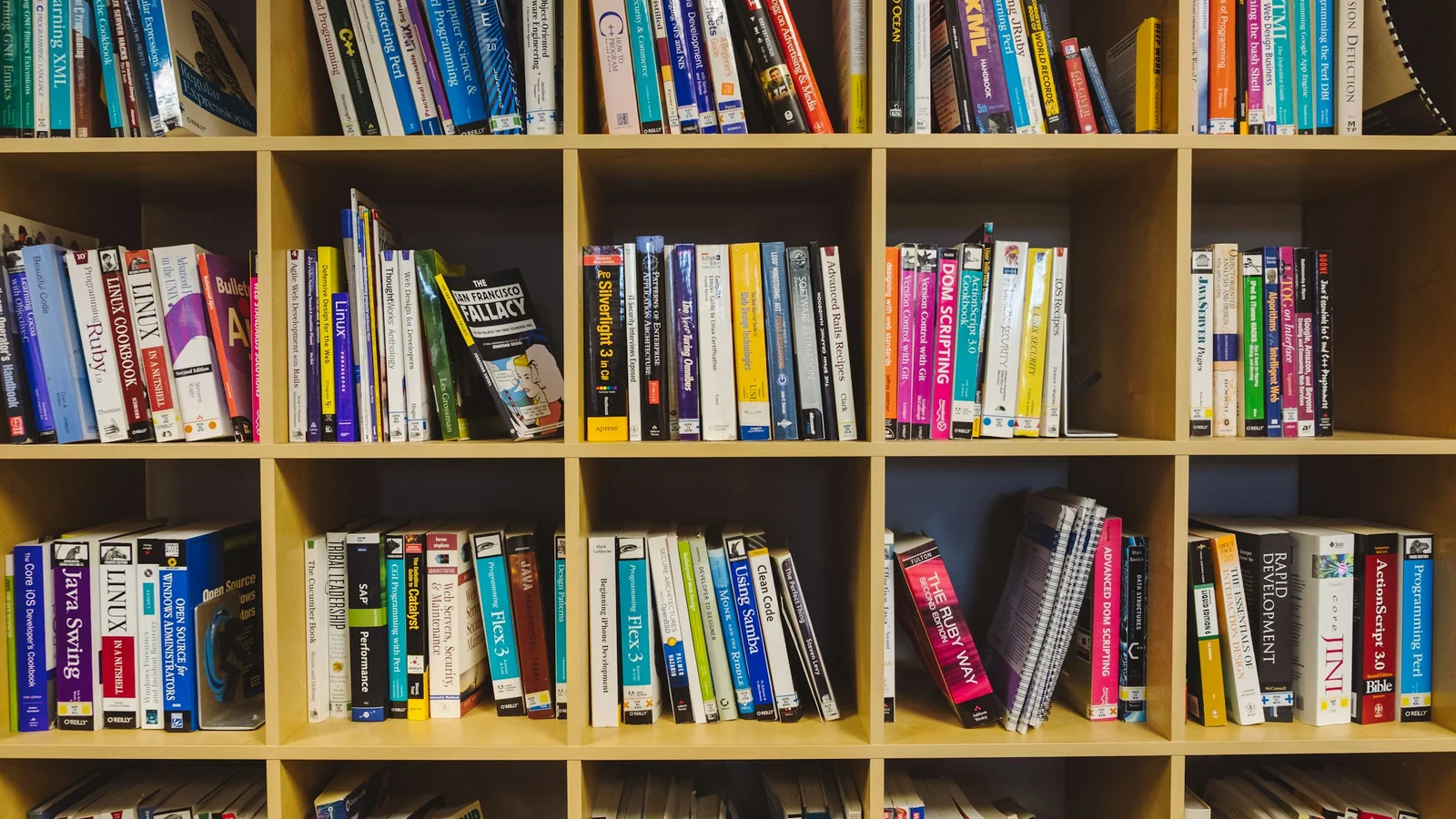A full bookshelf with varied books arranged across several shelves.
